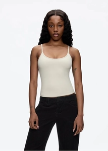 Close-up of slim shoulder straps and fine cotton texture on a cream fitted crop top tank