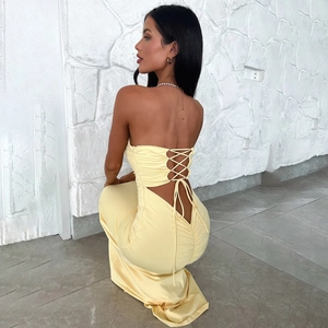 Detail of light yellow backless maxi dress with tie-up straps and elegant draping