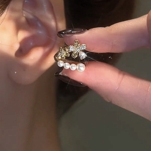 Detail of gold floral ear cuff featuring sparkling zircons and a row of four white pearls