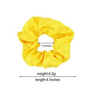 Yellow satin scrunchie with size measurements showing 4 inches stretched length