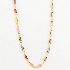 Macro shot of gold-plated chain necklace featuring vibrant multi-color rectangular crystals