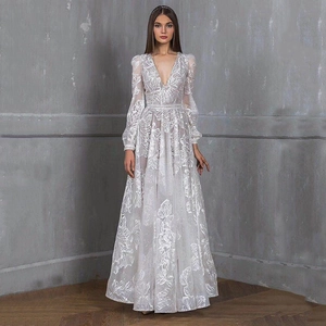 Close-up of white lace embroidery and delicate leaf patterns on a V-neck evening gown