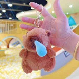 Close-up of a plush capybara keychain featuring a funny blue nose bubble and golden metal clip
