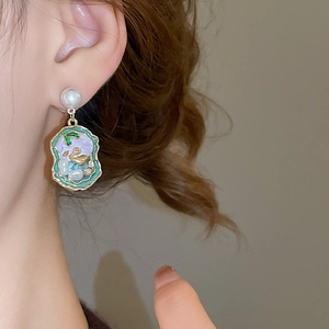Detail view of a French vintage earring with pearl stud and purple enamel pendant