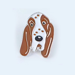 Macro shot of cartoon enamel basset hound pin showing detailed floppy ears and dog features