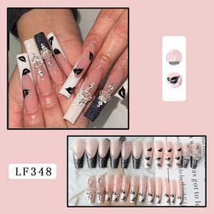 Detail of French press-on nails with glitter crown and lip prints in black and pink