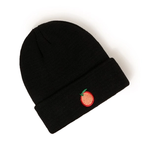 Détail d'un bonnet en tricot noir avec une broderie de fruit orange sur le revers plié