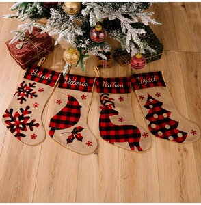 Detailed view of four personalized burlap Christmas stockings with festive embroidery