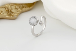 Close-up of rotatable silver ring with opal centerpiece and pave zircon accents