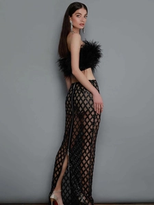 Detail of black feather strapless top with sequined plaid long skirt for evening wear