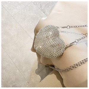 Close-up of heart-shaped mini evening bag with silver rhinestones and chain strap