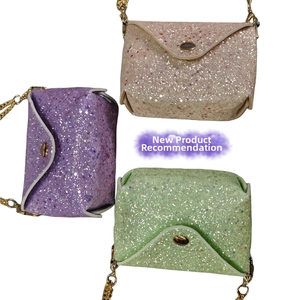 Three sequin mini crossbody bags in purple, pink, and green with gold chain straps