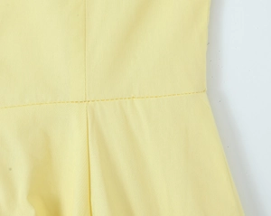 Gros plan des coutures fines et de la texture du coton sur un ensemble jaune d'été