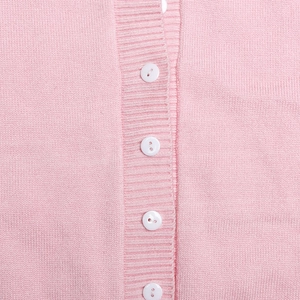 Detailed macro shot of fine pink knit fabric with ribbed placket and white buttons