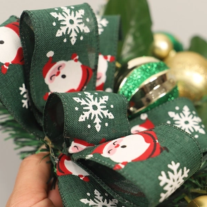 Green Christmas ribbon with Santa Claus print, golden ornaments, and pine needles decor