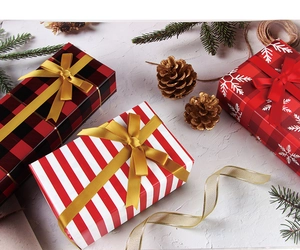 Close-up of festive gift boxes with plaid and snowflake patterns with gold ribbons