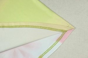 Dettaglio del tessuto in maglia sfumata con cucitura overlock verde chiaro rifinita