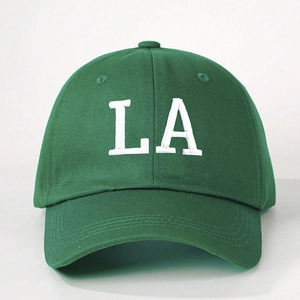 Close-up of white LA embroidery and premium cotton fabric texture on green baseball cap