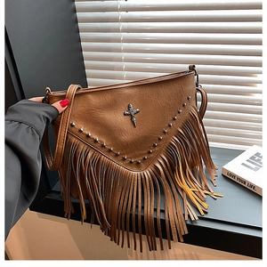 Gros plan d'un sac vintage en cuir marron avec des clous et des franges