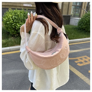 Foto street style di una borsa a mezzaluna rosa con ricamo a cuore trapuntato