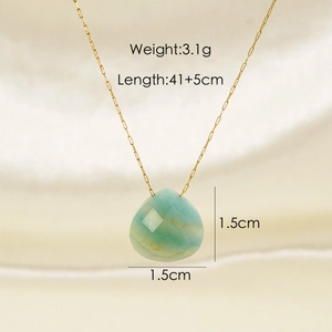 Natural light green gemstone teardrop pendant with fine gold chain on silk fabric