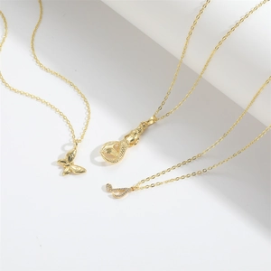 Gold music note and butterfly pendant necklace set with zircon inlay on white background