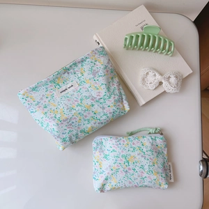 Flat lay of small floral canvas makeup bags with zippers and simple wish labels