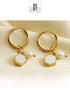 Detailed macro view of 18K gold-plated titanium steel earrings with pearls and hexagon charm