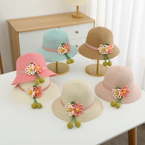Detail of colorful children straw sun hats with floral ribbons and handmade flowers