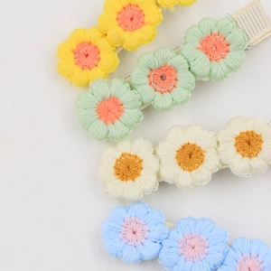 Close-up of colorful embroidered floral hair clips with detailed fabric petal texture