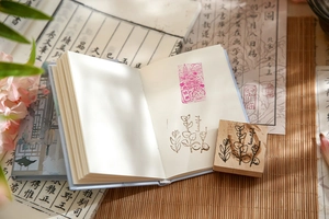 Close-up of botanical wooden stamp with leaf pattern on minimalist notebook pages