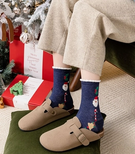 Cozy festive outfit featuring blue Santa Claus pattern socks and beige knitted trousers