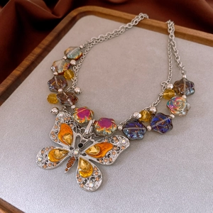 Detailed close-up of vintage butterfly flower necklace with crystals on a tray