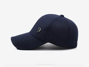 Détail du tissu de casquette bleu marine avec logo métallique bouclier argenté sur le côté