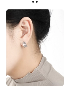 Detail view of silver honeycomb hoop earrings with micro-inlaid zircons on ear