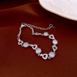 Détail du bracelet en argent avec pierres bleu clair rondes et breloques en cœur