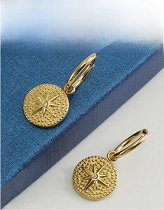Close-up of gold 18K stainless steel starburst earrings with sparkling zircon