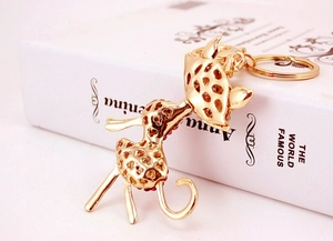 Macro shot of giraffe metal keychain with gold plating and sparkling red rhinestones