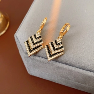 Elegant gold diamond-encrusted geometric drop earrings with black and white rhinestones