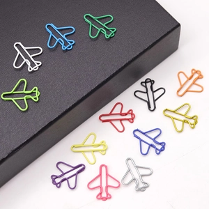 Top-down view of various colorful airplane shaped paper clips in metallic wire finish
