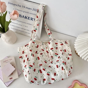 Detail of cherry print tote bag with bubble texture and a delicate ribbon bow accent