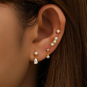 Detailed view of 4-piece S925 silver stud earring set with pearls and zircon on ear