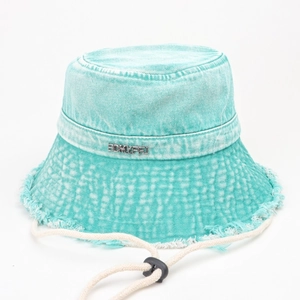 Dettaglio cappello alla pescatora in denim verde menta con bordi grezzi e placca in metallo