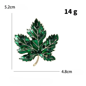 Detailed macro view of the green enamel maple leaf brooch with crystal studs and gold edges