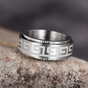 Rotating stainless steel spinner ring with Greek key pattern on textured stone