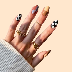 Short checkerboard press-on nails in brown and yellow with stylish gold ring accents