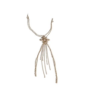 Golden body chain featuring a pearl flower pendant and elegant tassel fringe on white background