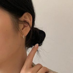 Close-up of minimalist 925 sterling silver hoop earring with zircon worn by a model