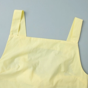 Detailed close-up of the square neckline and wide shoulder straps on a yellow summer top