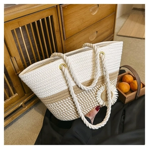 Close-up of woven tote bag featuring a daisy ornament on vintage wooden background